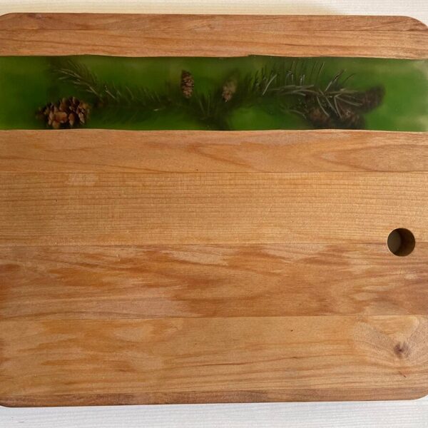 Griešanas dēlīts ar zaļganu epoksīdu un priežu skujām kopā ar čiekuriem